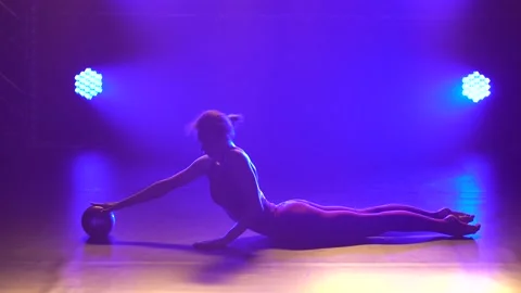 Cute gymnast performs elements of rhythmic gymnastics with ball. Girl dressed in Stock Footage 137512492