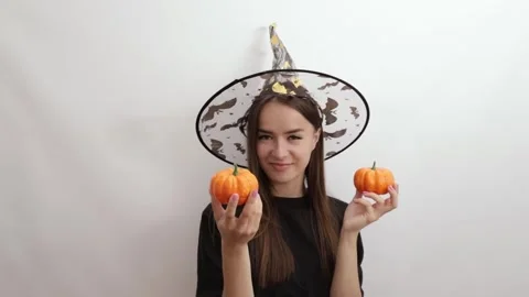 Cute halloween witch in a hat with pumpkins Stock Footage 246965609