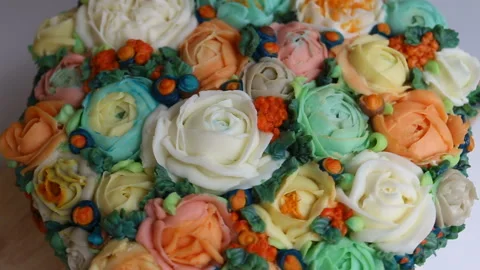 The cute handmade cake is decorated with realistic cream flowers of roses, Ranun Stock Footage 143725976