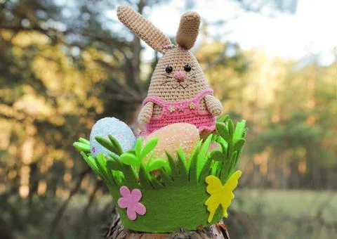 Cute handmade toy. knitted animal. easter bunny on a tree. basket with easter Photos
