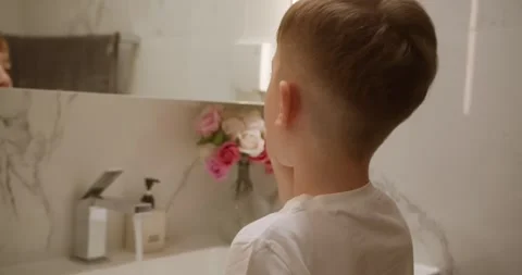 Cute handsome child brushing teeth in bathroom and smiling. Baby daily Stock Footage 283275500