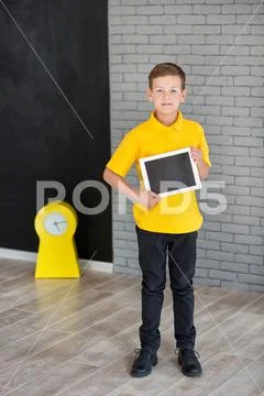 Cute handsome school boy in yellow t-shirt tie and stylish boots casuals stan Stock Photos