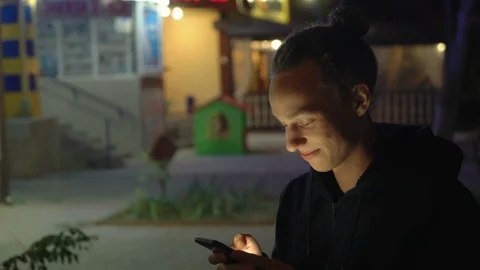 Cute handsome young boy using smartphone outdoors at night, 4k Видео 98502848