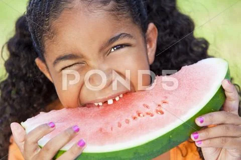 Cute happy african american girl child eating water melon Stock Photos