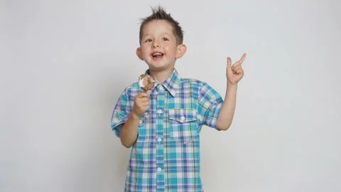 Cute happy child, eating ice cream, holding a stick and smiling into the camera Stock Footage 93541007