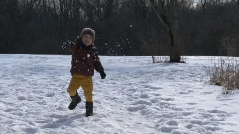 Cute happy child throws snow. Winter season, daytime, sunny weather Video stock 124395555