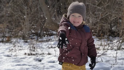 Cute happy child throws snow and smiles. Winter season, daytime, sunny weather Stock Footage 124395958