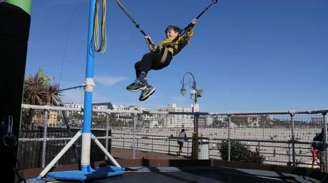 CUTE HISPANIC BOY BUNGEE JUMPS AT AMUSEMENT PARK. Stock Footage 63319769