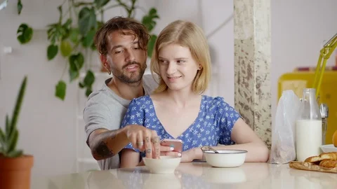 Cute Hispanic man coming from back to charming blonde girlfriend staying online Stock Footage 108796588