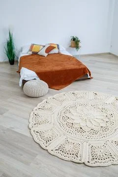 Cute homemade knitted pattern of thick threads made by hand: a handmade rug m Stock Photos