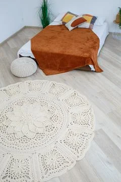 Cute homemade knitted pattern of thick threads made by hand: a handmade rug m Stock Photos