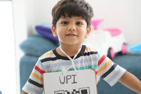 Cute Indian child dressed up with a UPI QR code sign for a school activity Stock Photos