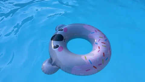 Cute inflatable sloth pool float with colorful sprinkles pattern floating on Stock Footage 316130489
