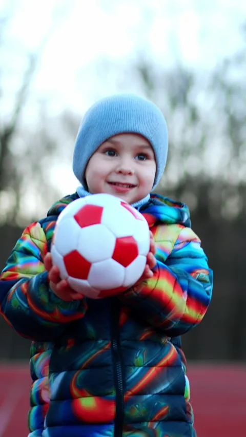 Cute kid approaches the camera carrying a ball. Lovely smiling baby having fun Vídeos de archivo 337509754
