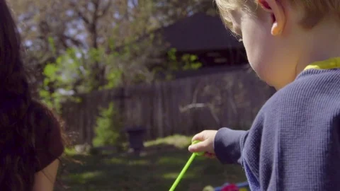 Cute kid blows bubbles toward camera in extreme close up Video stock 75023661