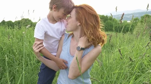 Cute kid boy with his mother on a summer meadow Stock-Footage 79934053