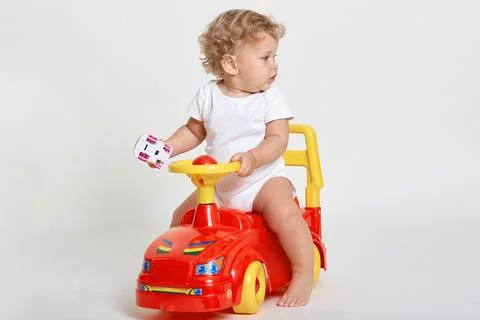 Cute kid boy on light background playing with tolocar machine, holding toy .. Stock Photos
