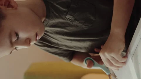 Cute kid boy making home decorations while sitting at table, children making Video stock 256099376