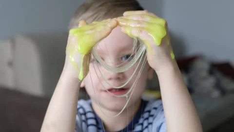Cute kid boy playing with light green slime. Close up 스톡 동영상 130511453