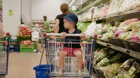 Cute kid boy in a summer hat sitting in shopping cart Stock Footage 149322728