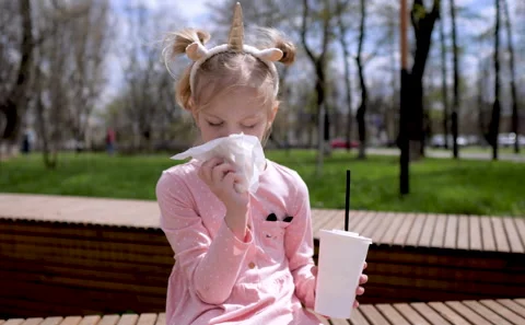 Cute kid drinks a milkshake and eats fast food Stock Footage 193768557