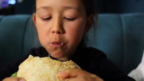 Cute kid girl eats hamburger. Stock Footage 233164612