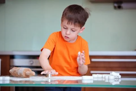 Cute kid helping at kitchen with baking cookies Foto stock