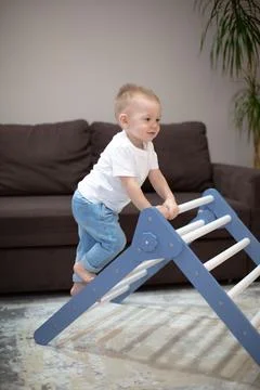 A cute kid performs gymnastic exercises on the stairs. Children's sports wooden Stock Photos
