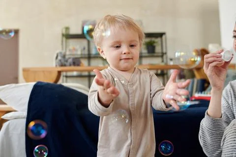 Cute kid playing with soap bubbles Stock Photos