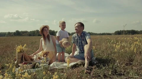 Cute kid plays with his toy and his parents cheer him up Stock Footage