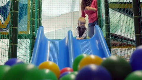 A cute kid pulls off the blue roller coaster in an amusement park. Multicolored Stock Footage 75043116