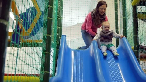 A cute kid pulls off the blue roller coaster in an amusement park. Multicolored Stock Footage 75043200