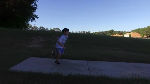 Cute kid running on a sidewalk Stock Footage 75163853