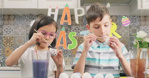 Cute kids paint easter eggs in a room decorated for Easter Day Stock Footage 234509199