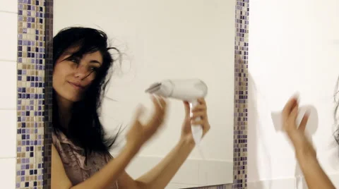 Cute lady having fun drying long hair in front of mirror Stock Footage 60605709