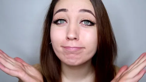 Cute lady in makeup is surprised and throws up hands and smiling with braces on Stock Footage 258159881