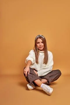 Cute lady sitting on the floor in studio posing Stock Photos