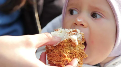 A cute little baby eats cake.A mother feeds her baby cake. Stock Footage 37189645