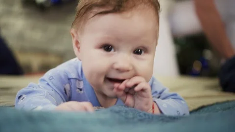 A cute little baby is looking into the camera, smiles and laughs Stock Footage 86518075