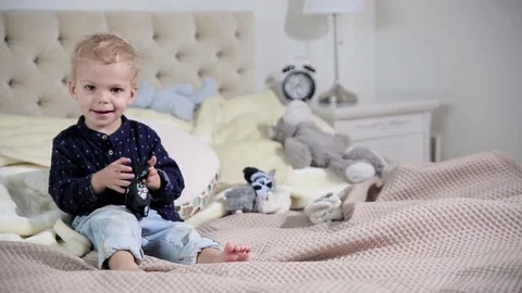 Cute little blond boy is trying to dress up. FULL HD. DOLLY SHOT Stock Footage 72828381