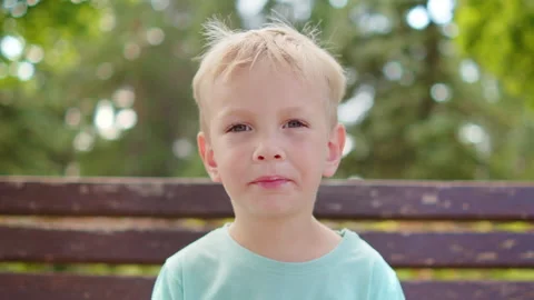 Cute little blonde boy biting an ice cream cone and smiling. Smiling kid ea.. Stock Footage 339529292