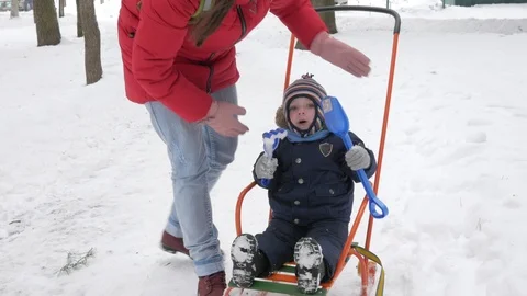 Cute little boy and young mother play in the winter with snow in the park. Blue Stock Footage 86822011