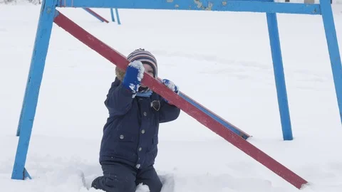 Cute little boy and young mother play in the winter with snow in the park. Blue Stock Footage 86830692