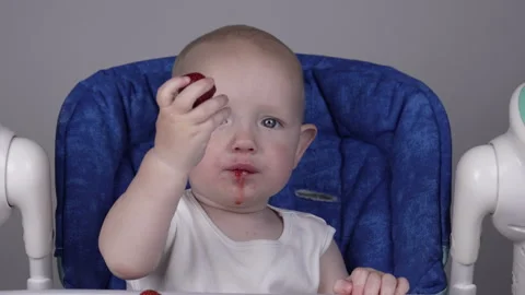 A cute little boy appetizingly eats fresh strawberries and offers to try them. Stock Footage 276863992