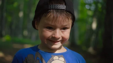 Cute little boy in black cap looking at camera, smiling. Portrait of nice Stock Footage 95934792