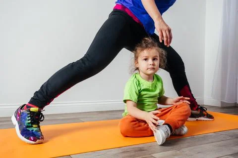 Cute little boy is bored while mother doing morning yoga Stock Photos
