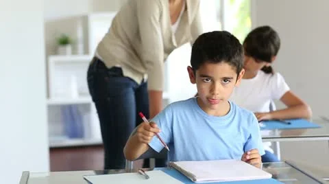 Cute little boy in class showing notebook towards camera Stock Footage 14832743