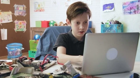 Cute little boy coding new computer components using his laptop computer type on Stock Footage 75687091