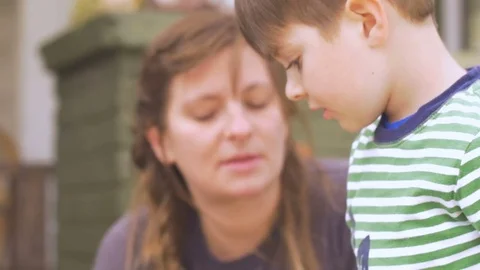 Cute little boy decorating easter eggs with his family during the holidays Stock Footage 80012648
