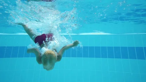 Cute little boy dives in pool with open eyes and floated back 動画素材 35235647
